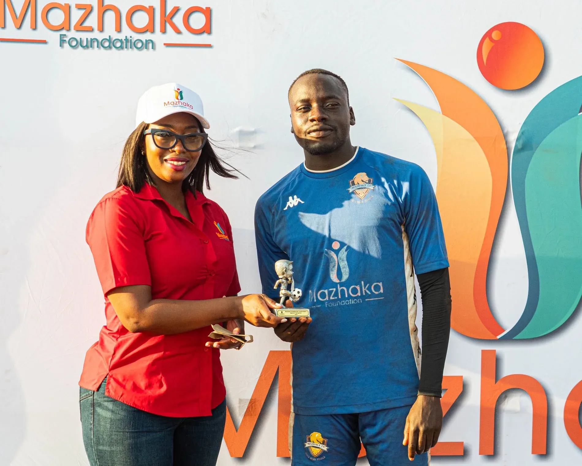 Man of the Match award being presented in front of the Mazhaka Foundation backdrop