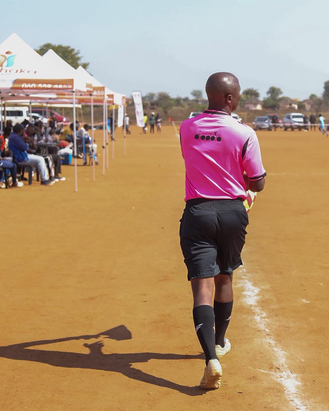A footballer crosses the tournament pitch