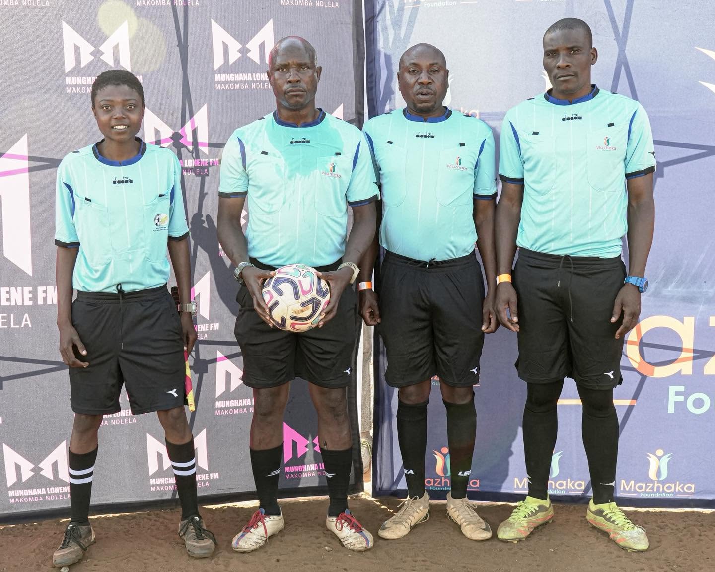 Football team members and coaches pose together