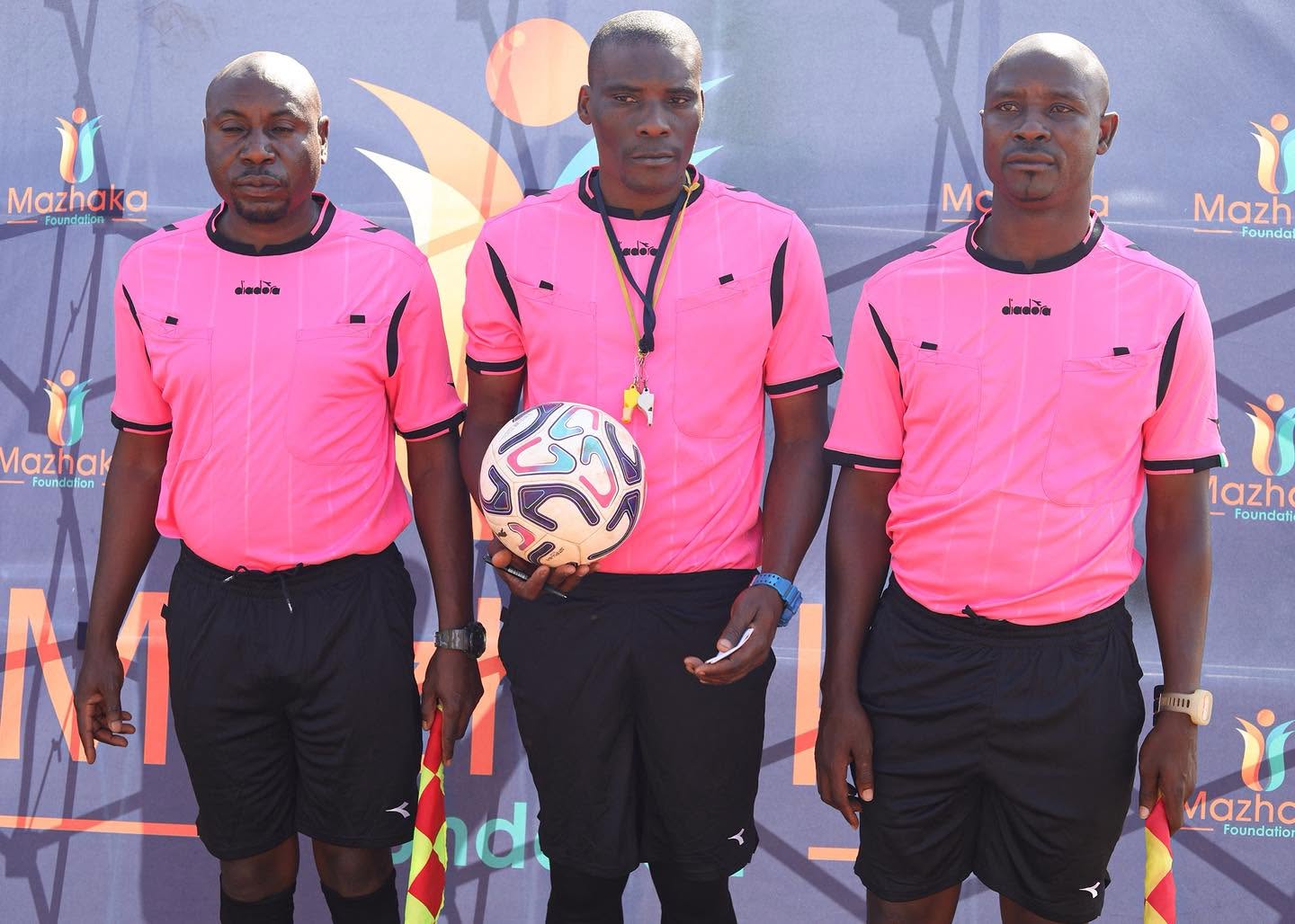 Match officials line up with the football