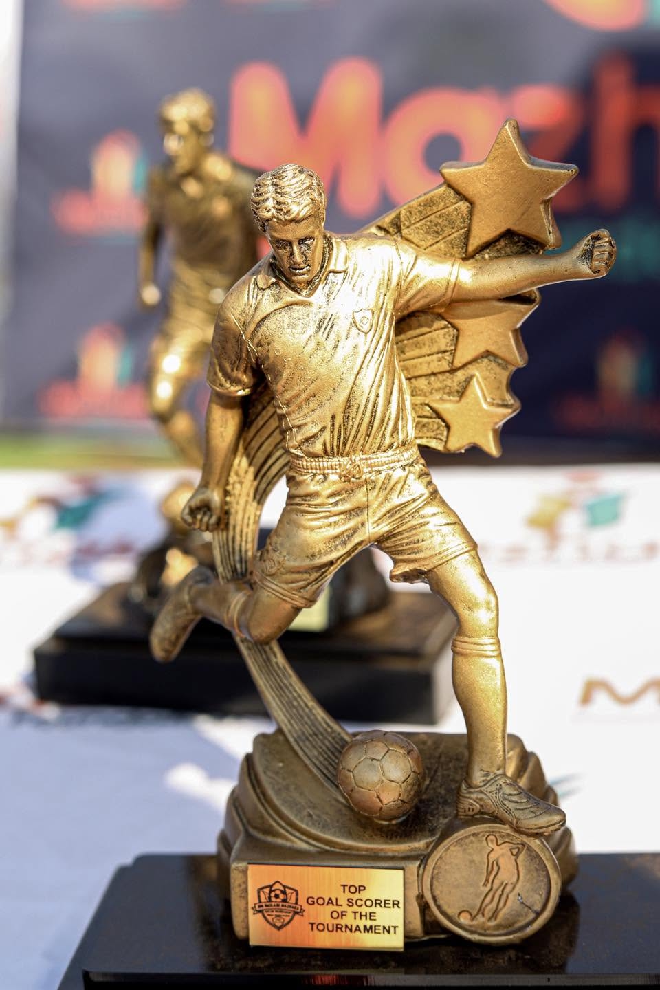 A golden footballer trophy on the awards table