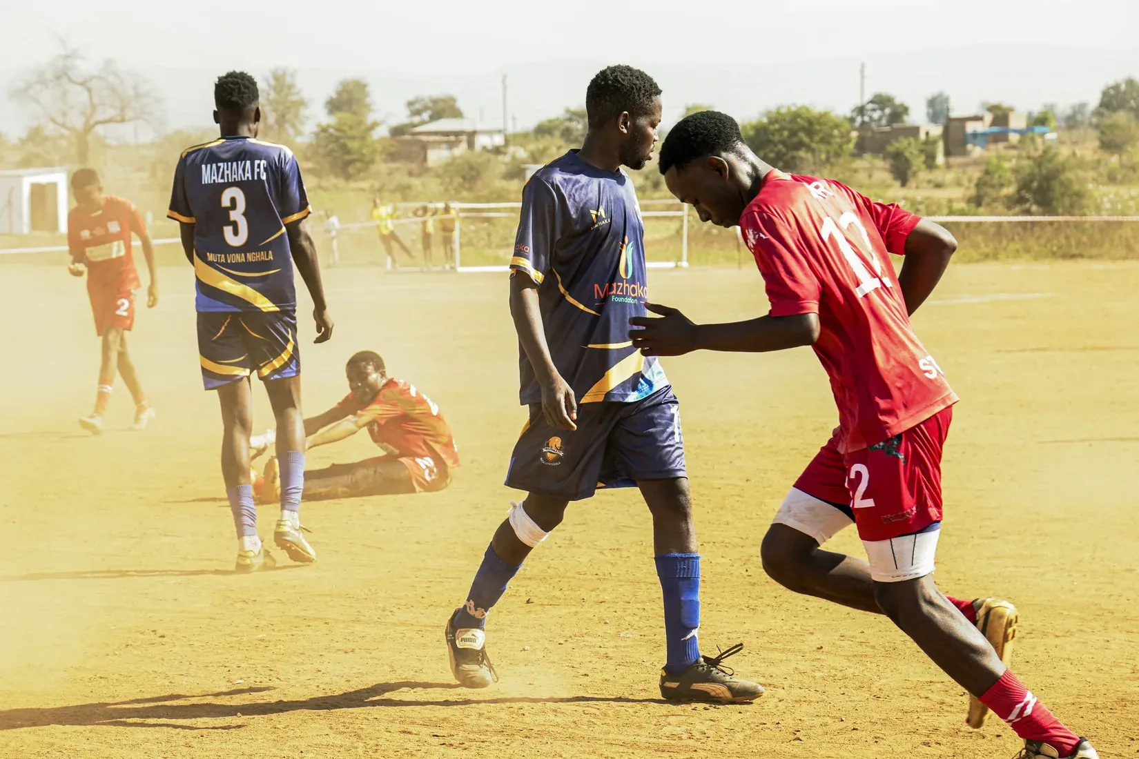 Players contesting the ball during a village football match
