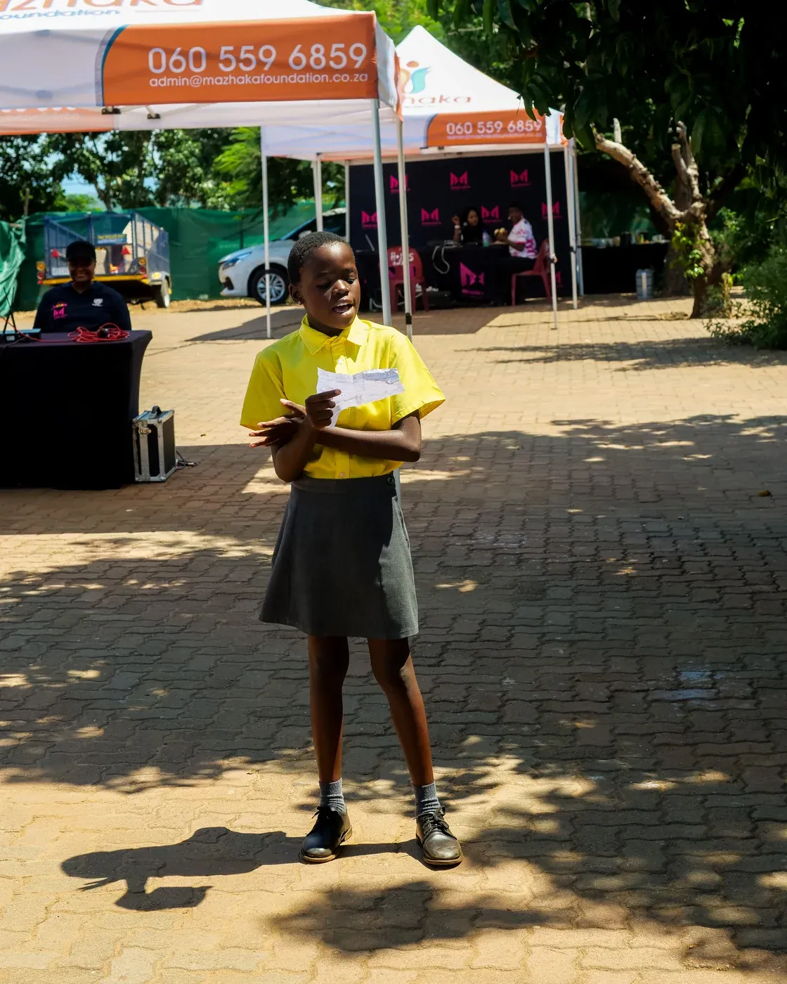 A learner speaking at a school-shoe donation event