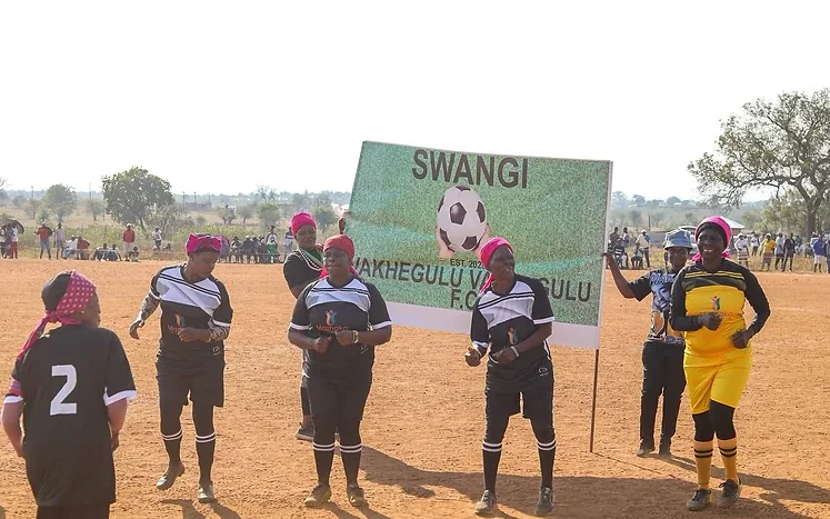 Players standing beside a sign